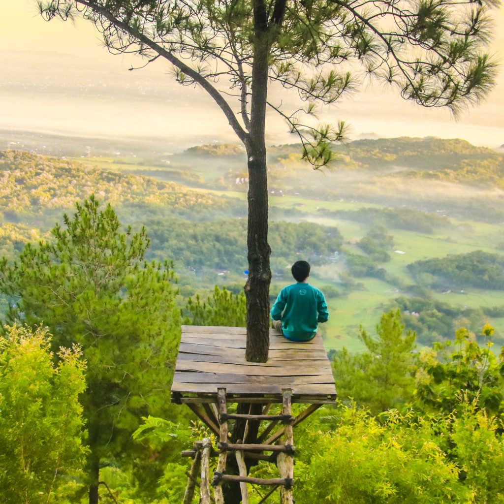 Mediation and yoga retreats visitor meditates in nature