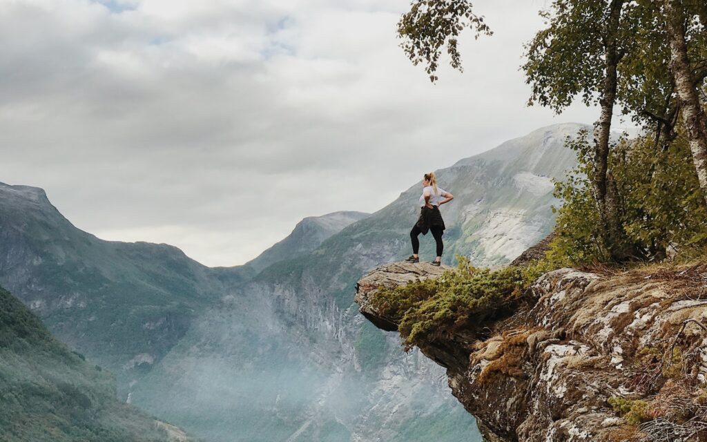 Adventure tourism: Woman standing a top a mountain 